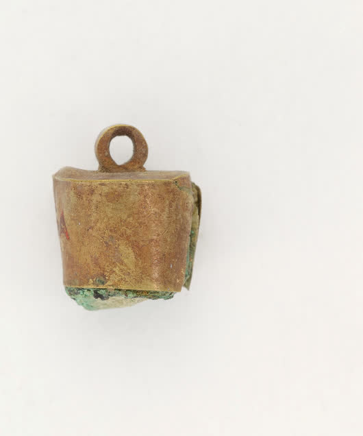 Small bronze pendant on a plain ground, studio photograph